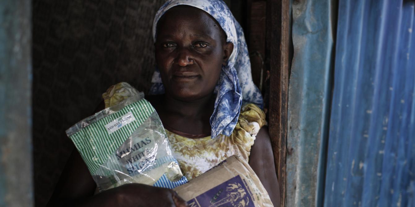 Jane Grace, 48, mother of three, who also looks after an orphaned nephew, stands in the doorway of her home in the Lunga Lunga area of the Mukuru informal settlement. Photo Credit: Sam Tarling Jane Grace, 48, mother of three, who also looks after an orphaned nephew, stands in the doorway of her home in the Lunga Lunga area of the Mukuru informal settlement. Photo Credit: Sam Tarling